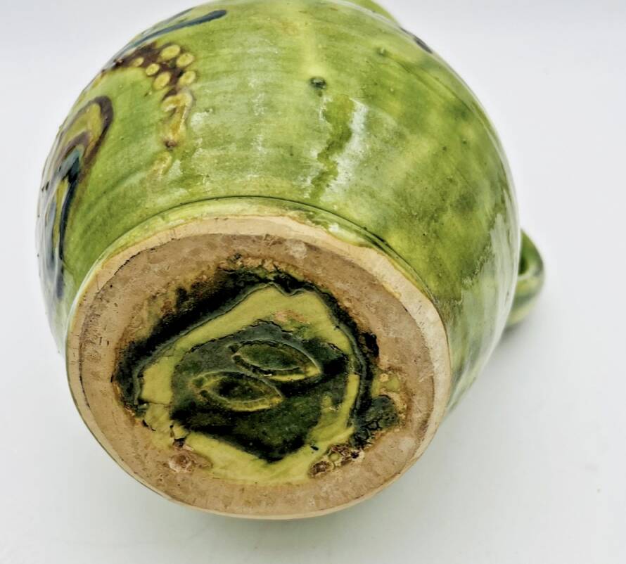 Green stoneware pitcher with flower and brown bird decoration