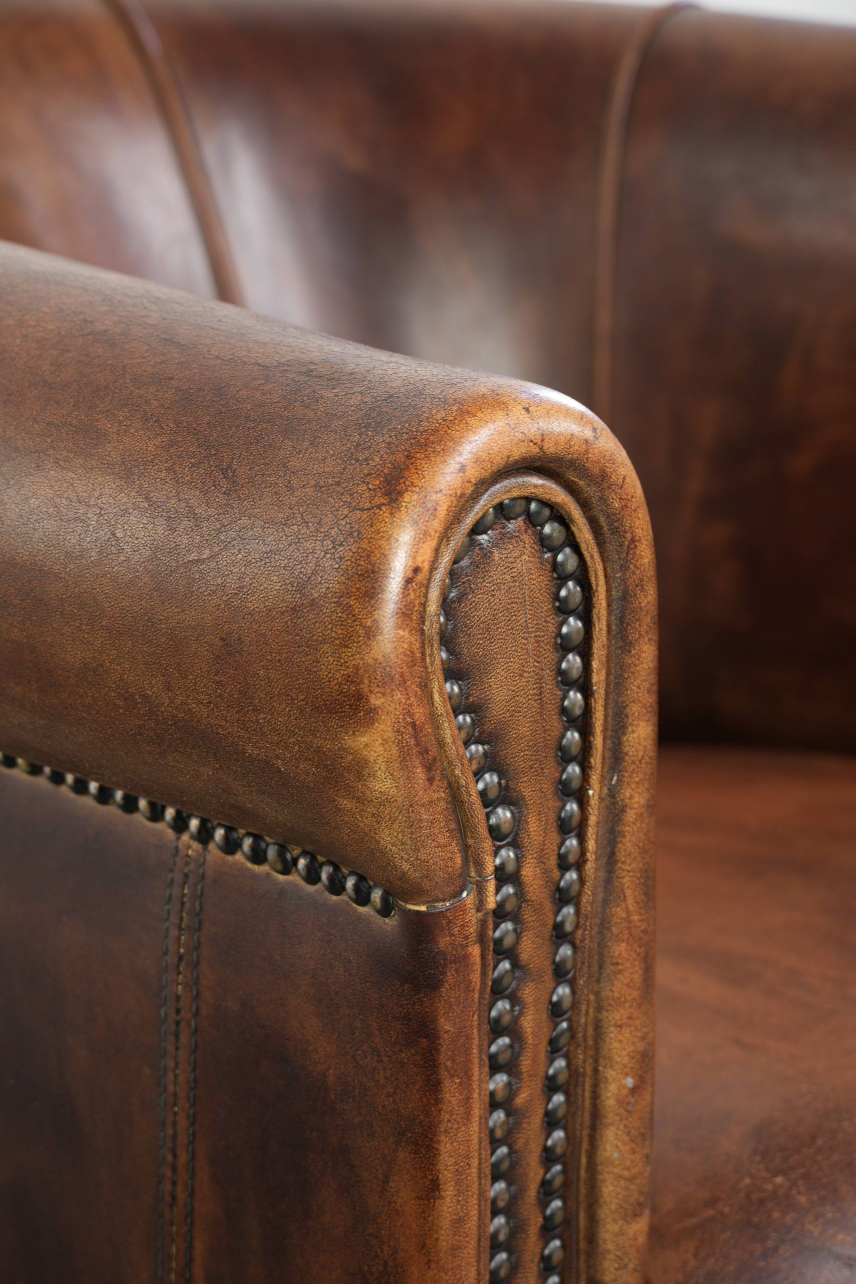 Sheepskin clubarmchair with beautiful patina finished with decorative nails