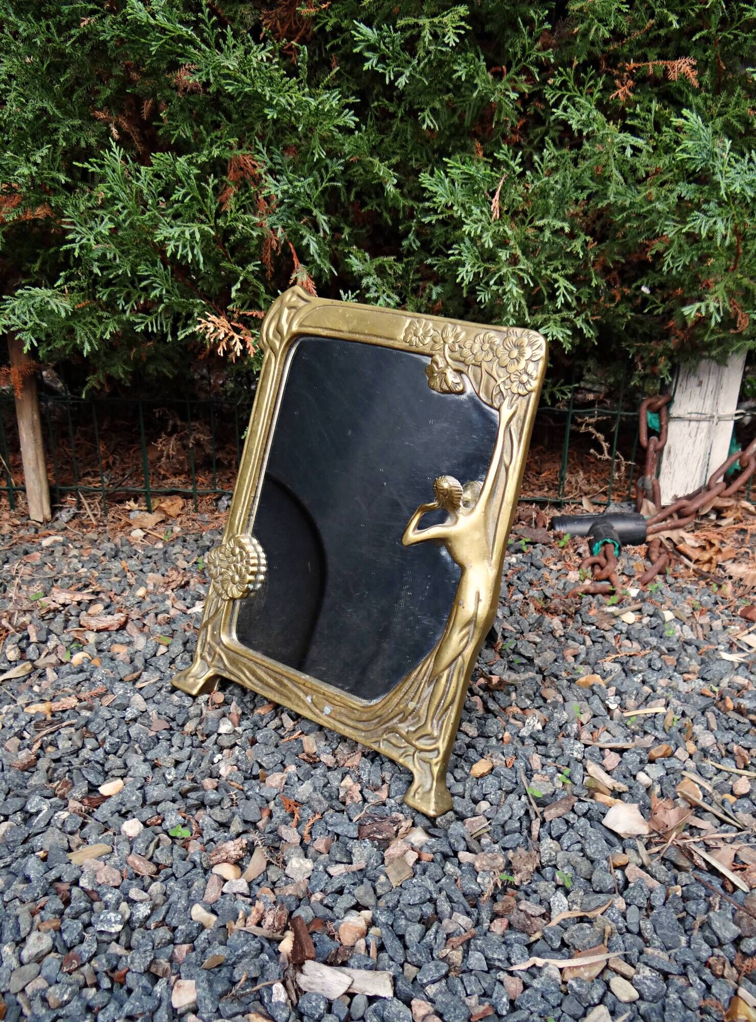 Art Nouveau mirror in gilded brass with a woman figure emerging from a vintage frame