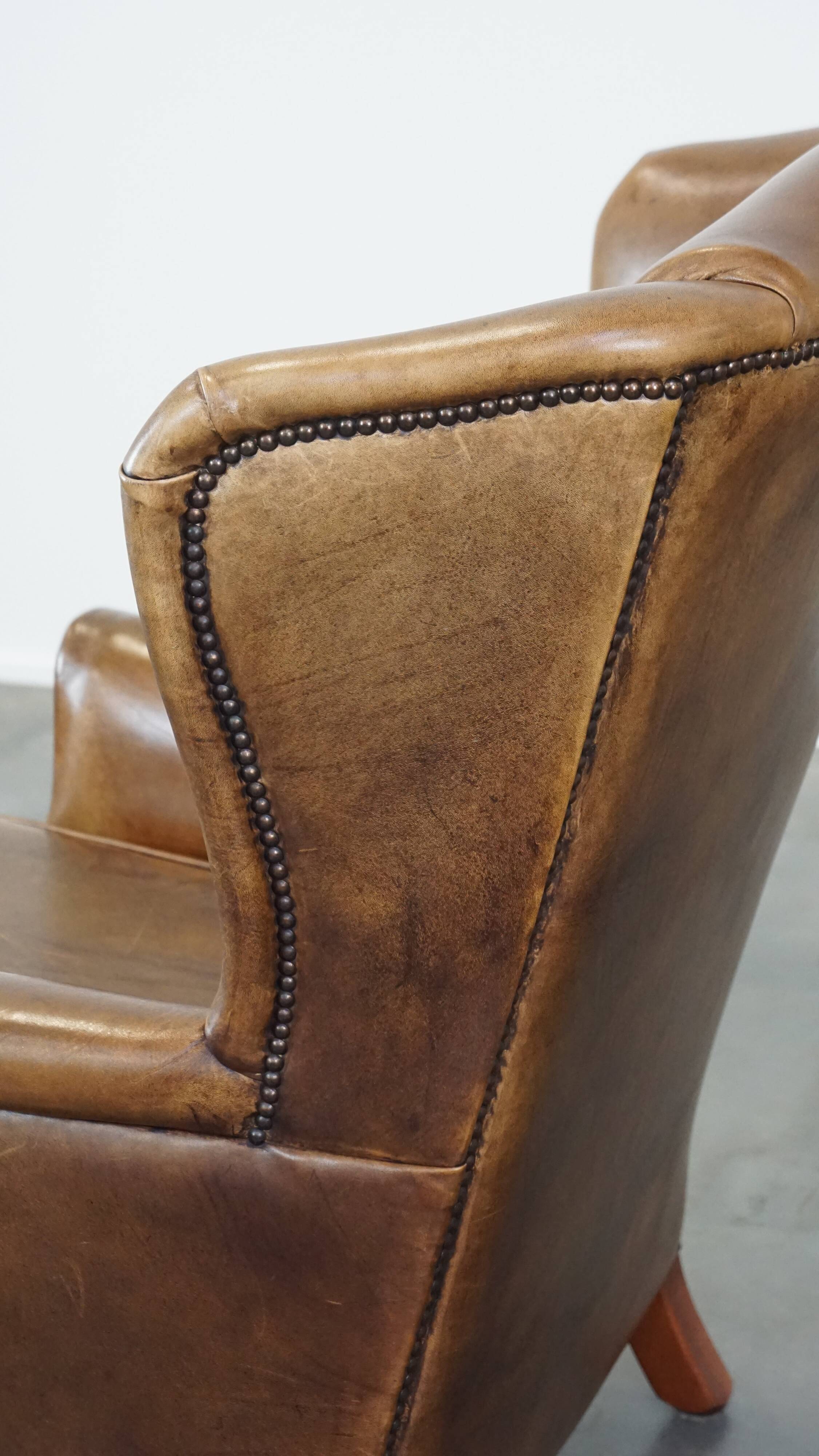 Charming sheep leather wingback armchair with a beautiful patina and excellent seating comfort