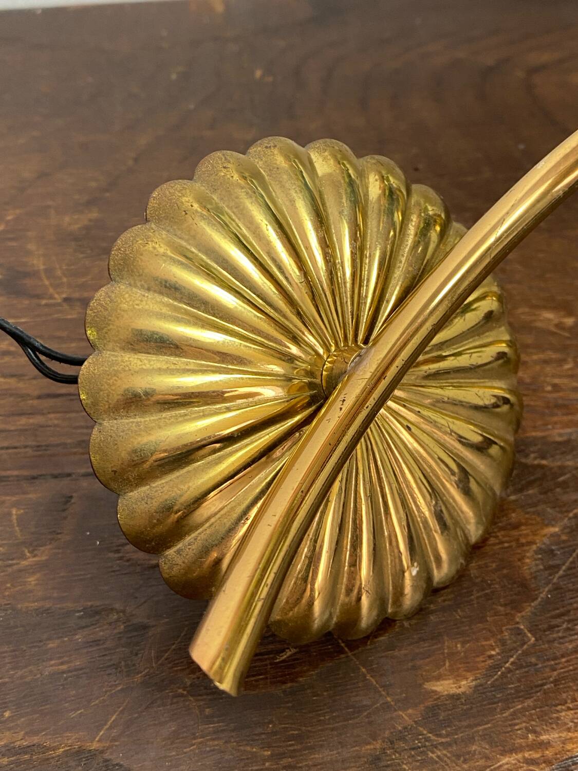 Gold metal wall light with ribbed glass.