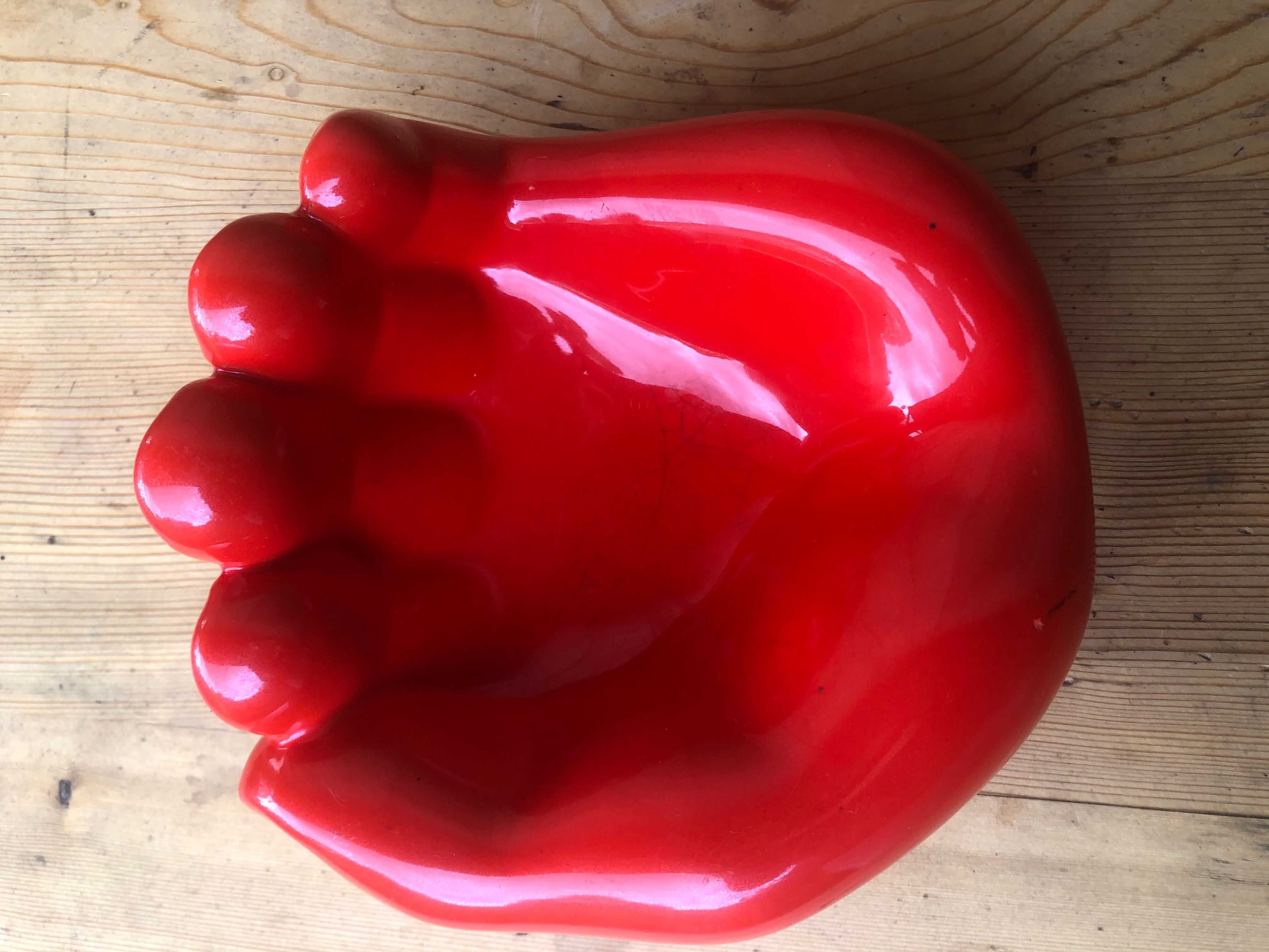 Empty pocket in the form of a red ceramic hand 60/70