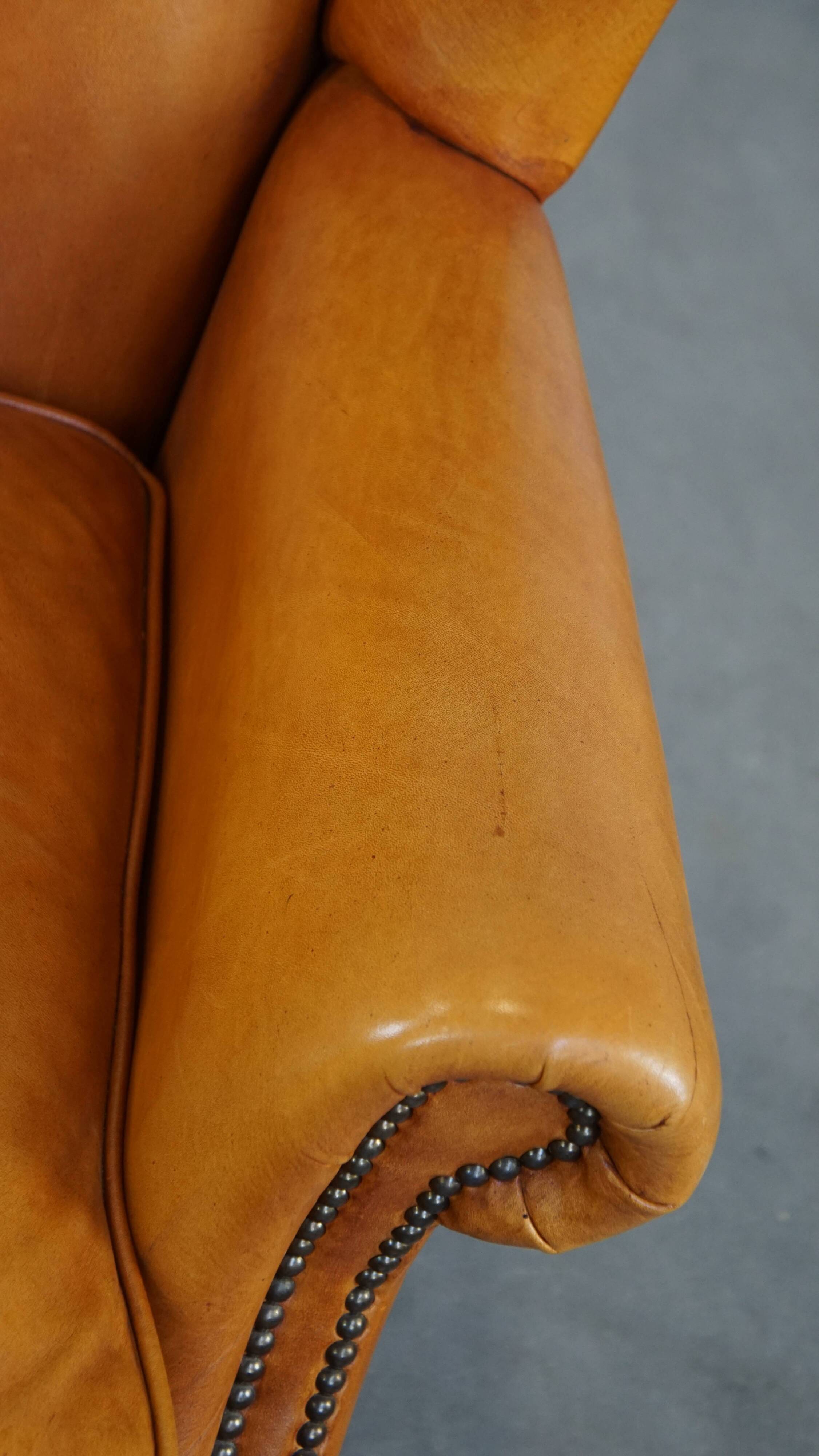 Cow leather wingback chair finished with decorative nails