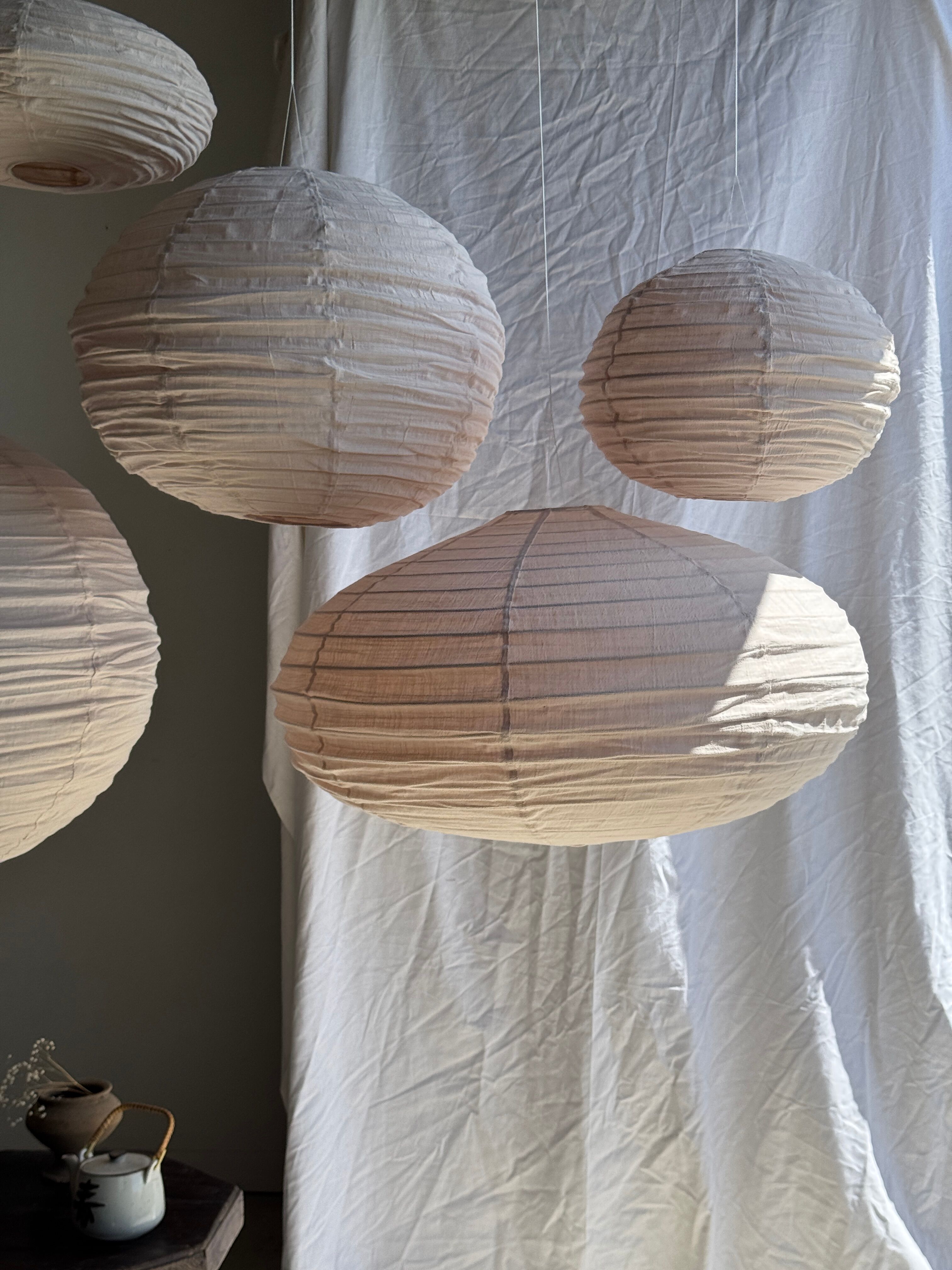 Grande suspension en rotin et lin naturel japonisante ovale aplatie rosée