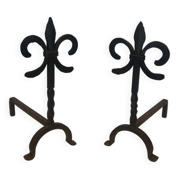 Pair of wrought iron fire dogs with fleur-de-lis.