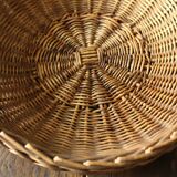 Round wicker basket with a rigid handle.