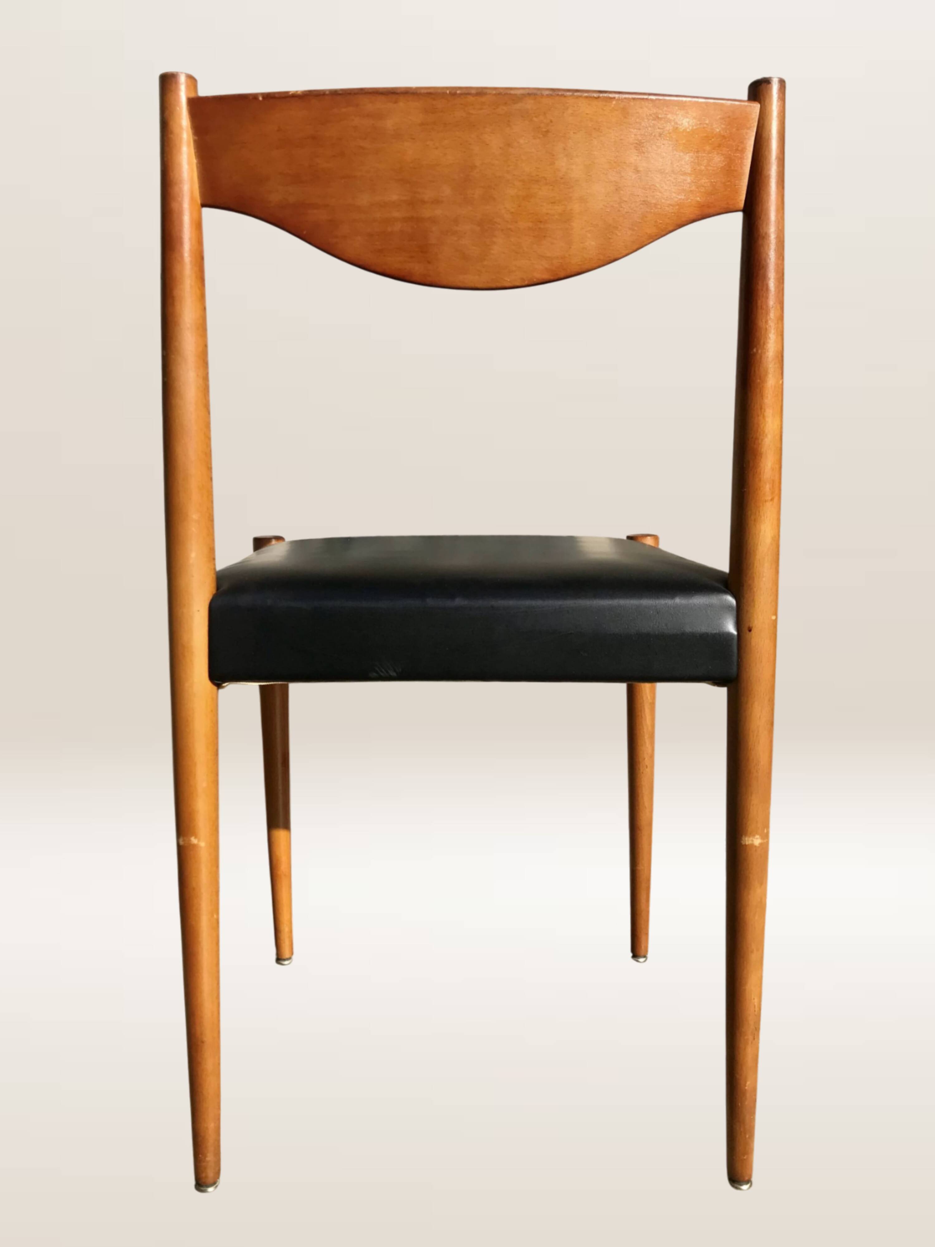 Set of 6 modernist chairs with black faux leather seats.