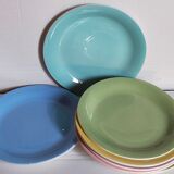 Seven pastel-colored plates mixed with vintage earthenware