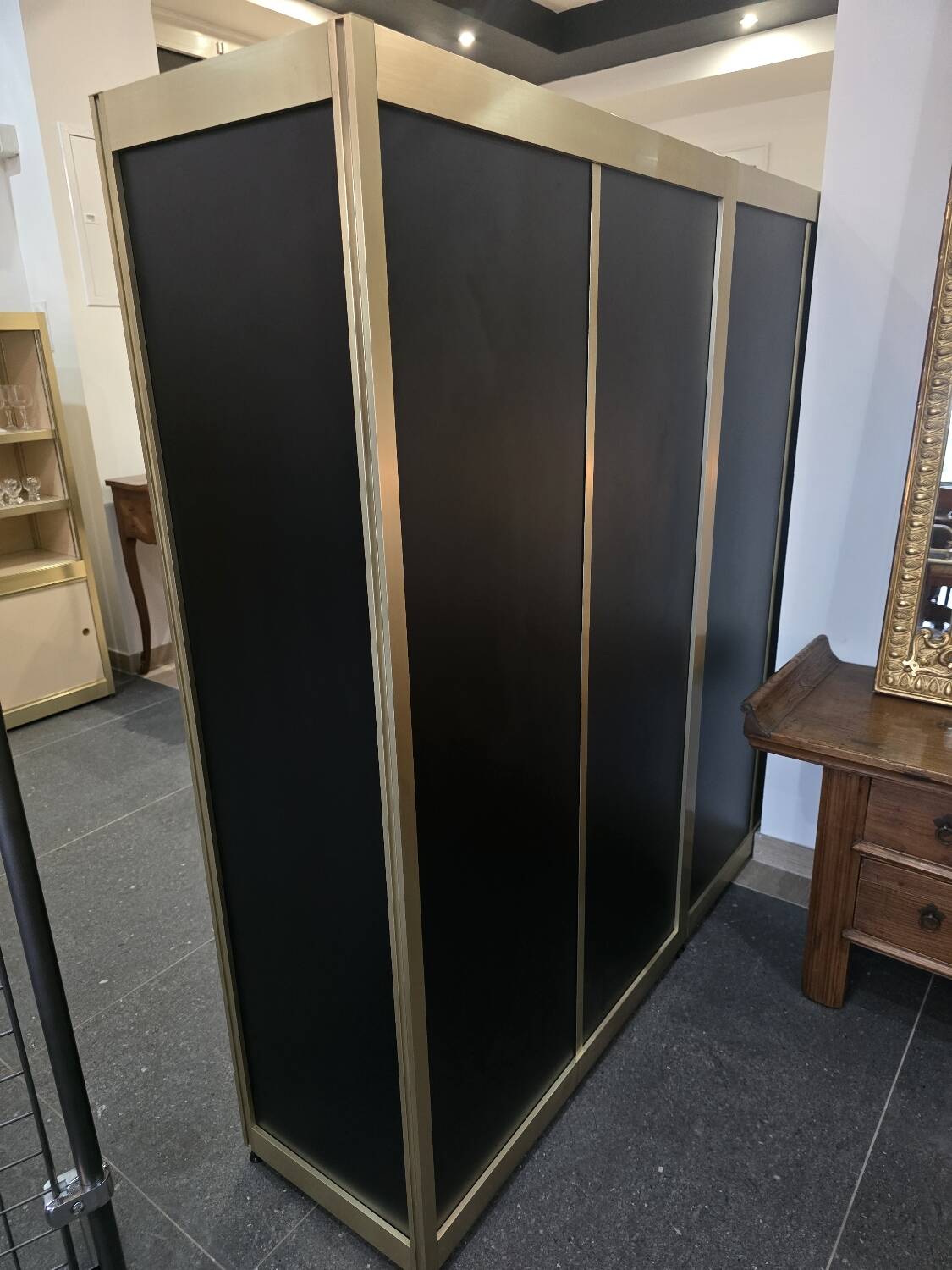 1970s design library with gold metal and lacquered wood.