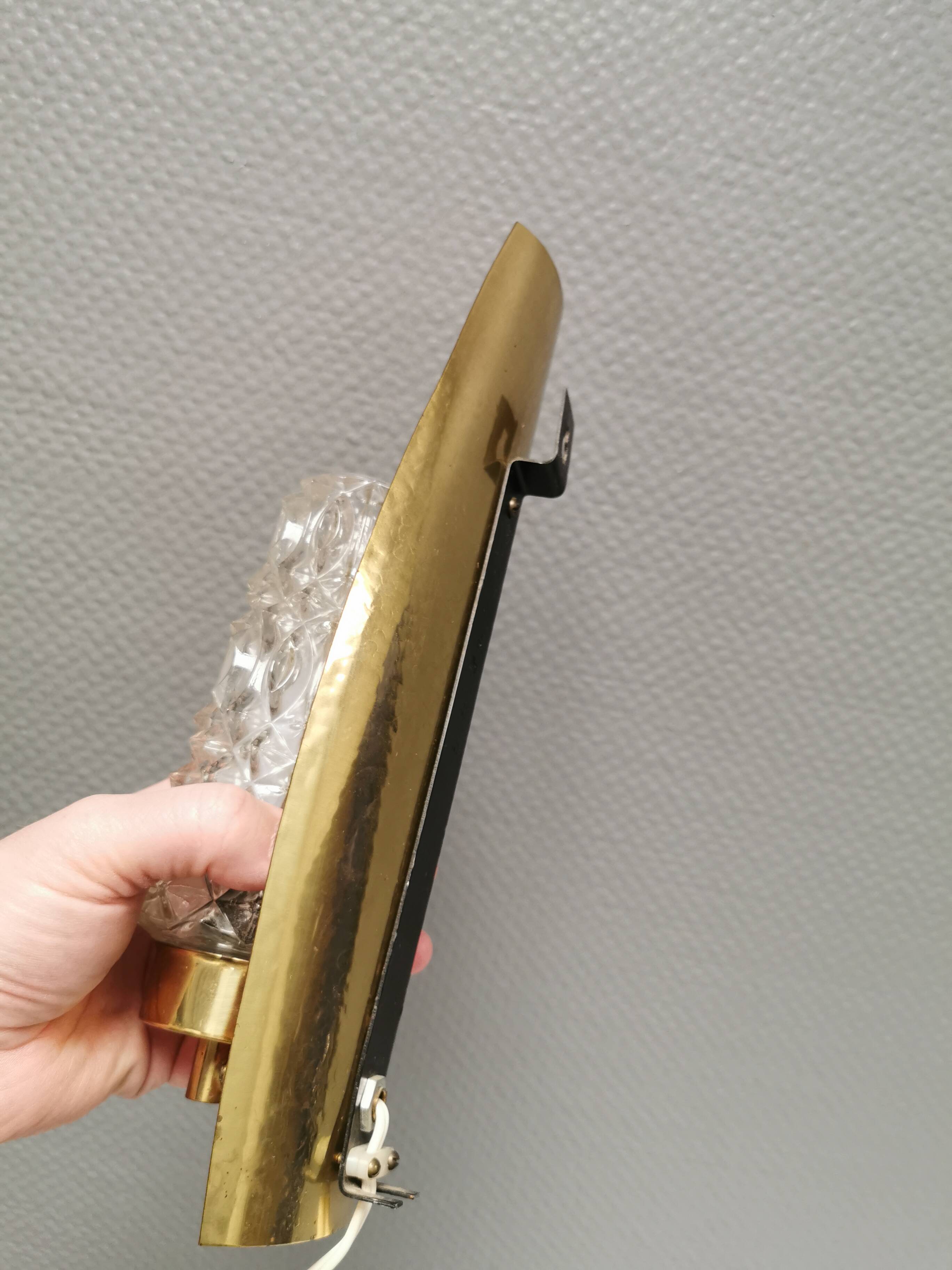 Older wall lamp in brass with hard pressed glass shade.