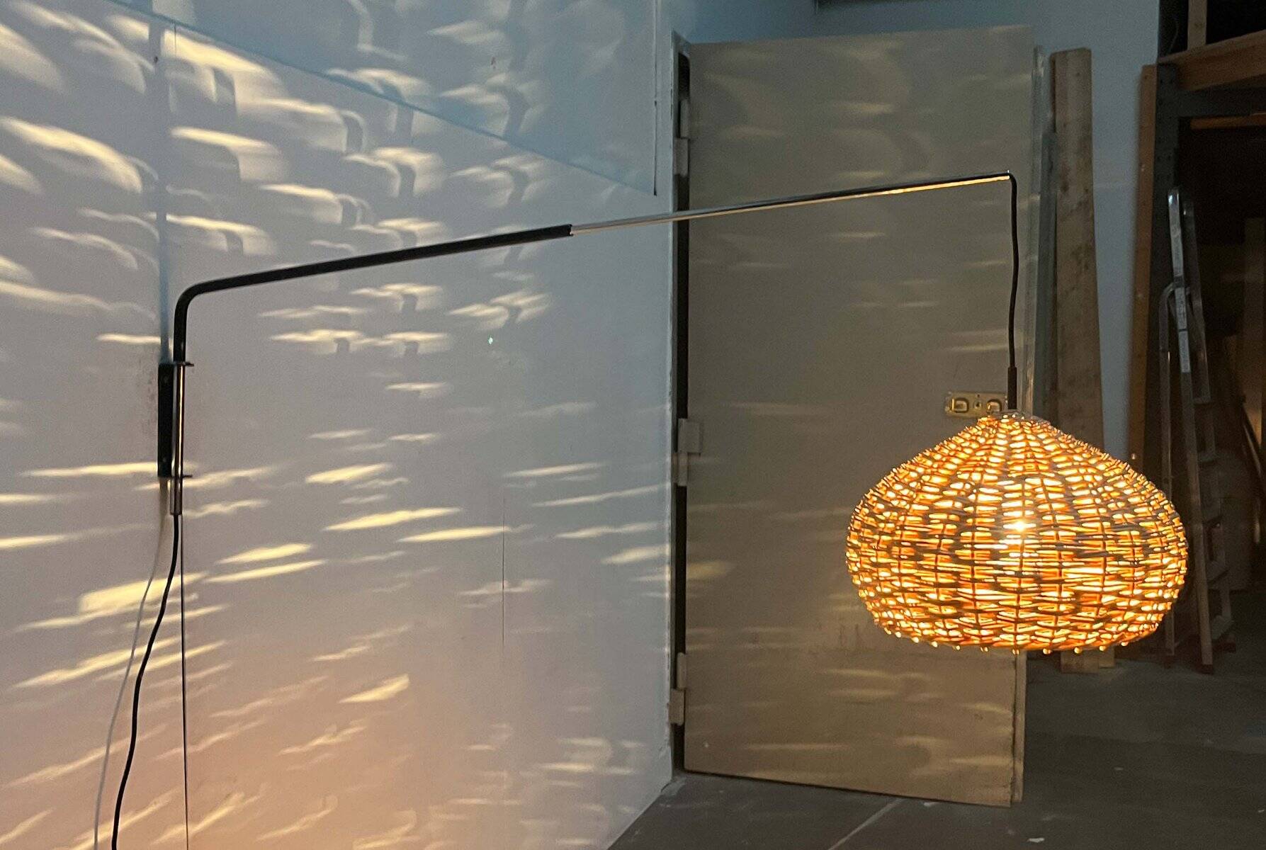 Mid-century modern Danish extendable cantilever wall lamp with a rattan shade, 1960s.