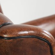 Unique sheepskin armchair with warm deep colours finished with black piping