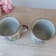 Set of two speckled stoneware mugs with small wildflower bohemian retro design.