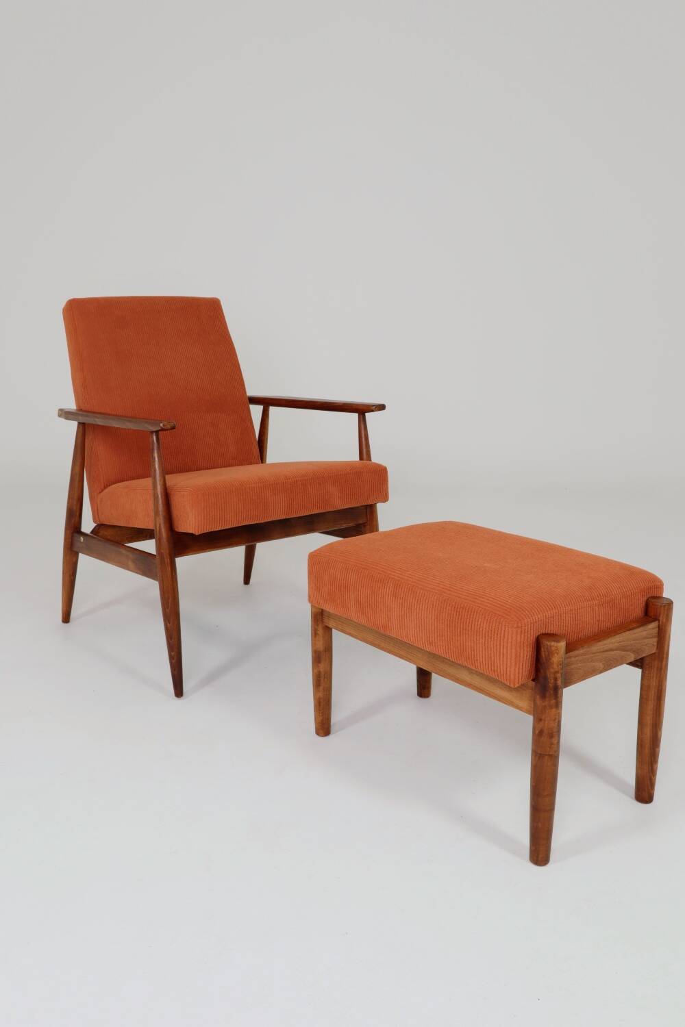 Vintage armchair and footrest in orange corduroy.