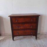 Antique oak chest of drawers on castors with brass handles and carved details