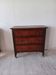 Commode ancienne sur roulettes en chêne sculpté et laiton