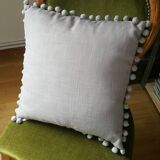 Gray cushion with pompoms