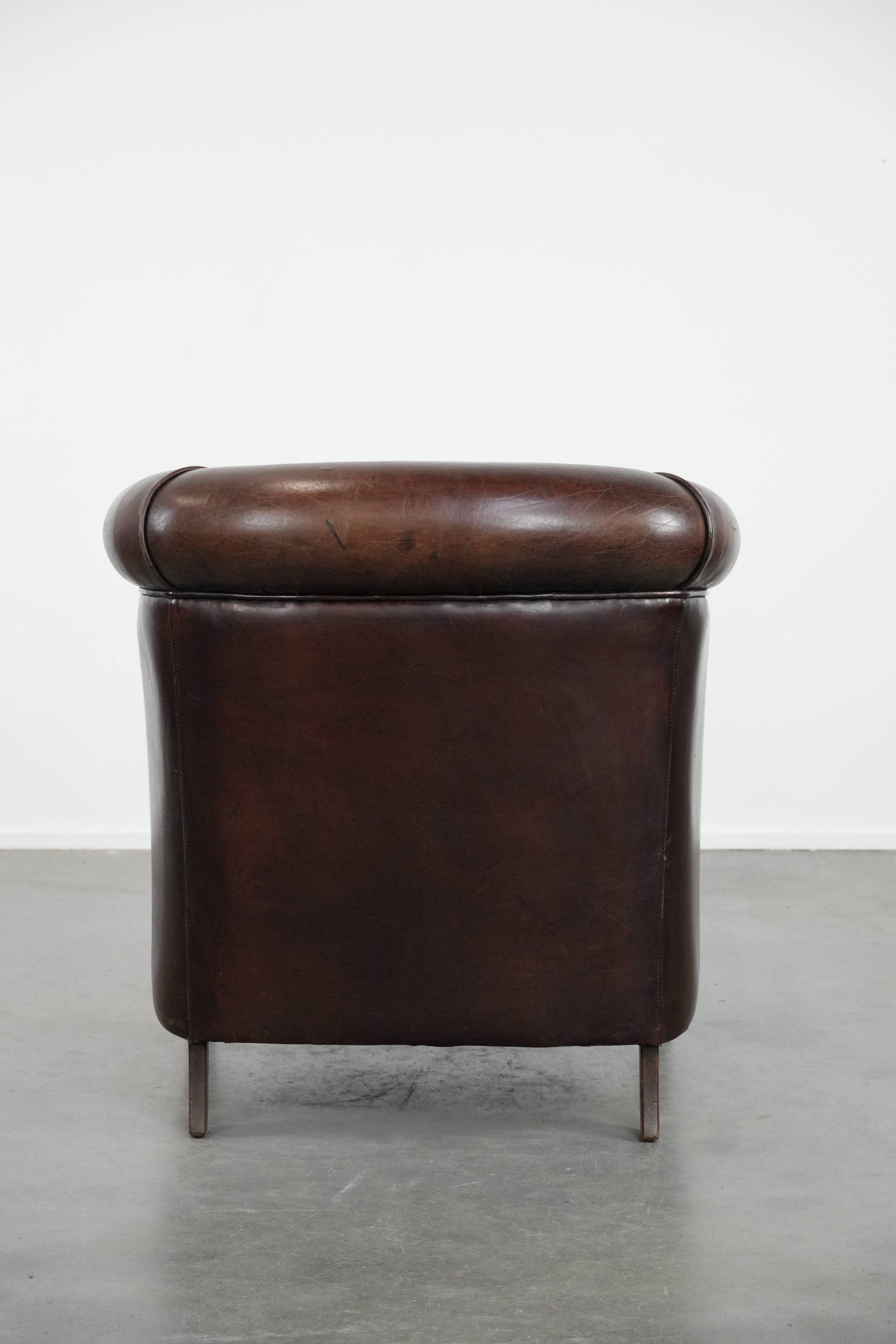 Stylish and sturdy dark brown club armchair made of sheepskin leather