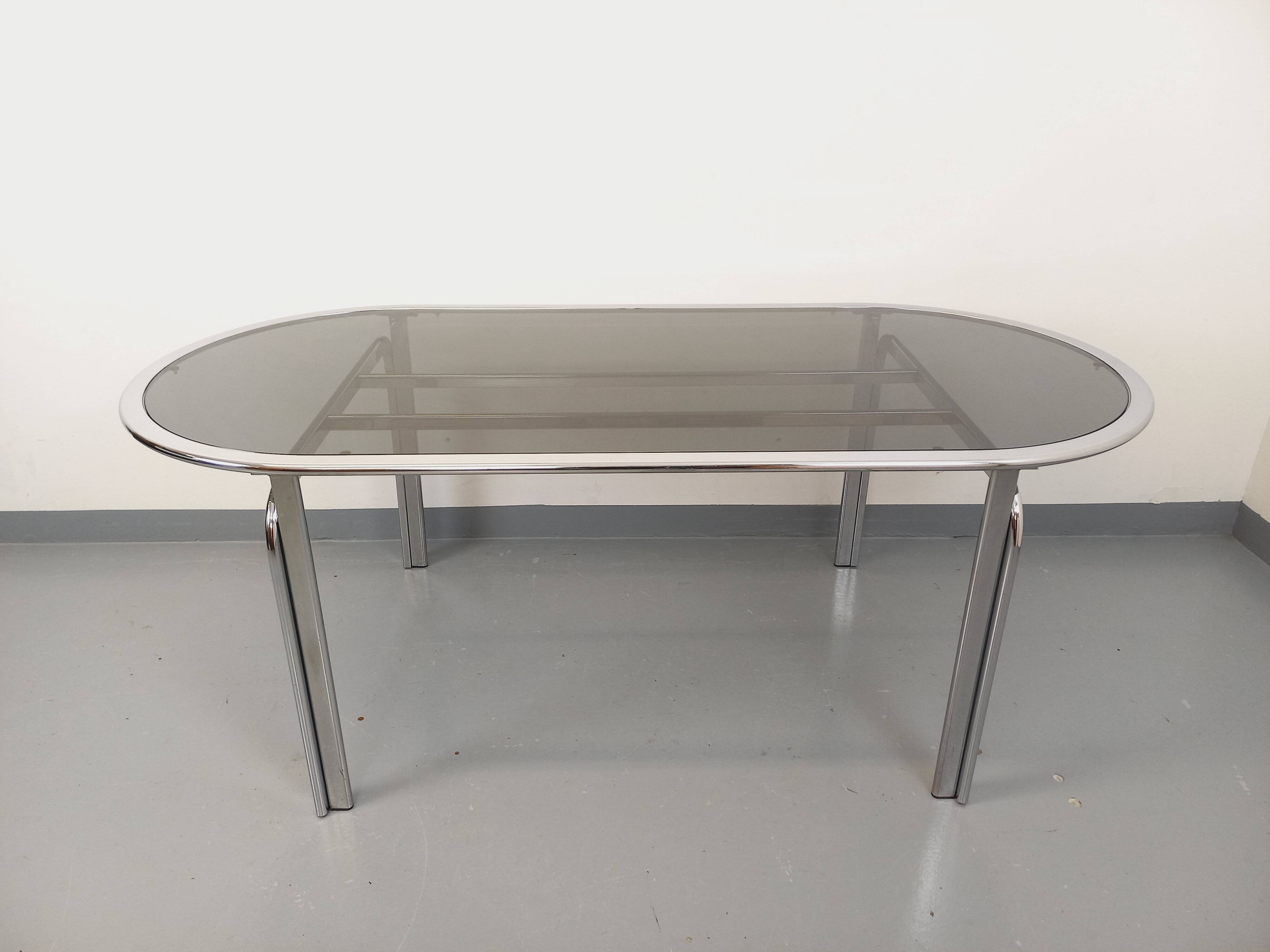 Vintage oval dining table in smoked glass and chrome metal, Space Age style.