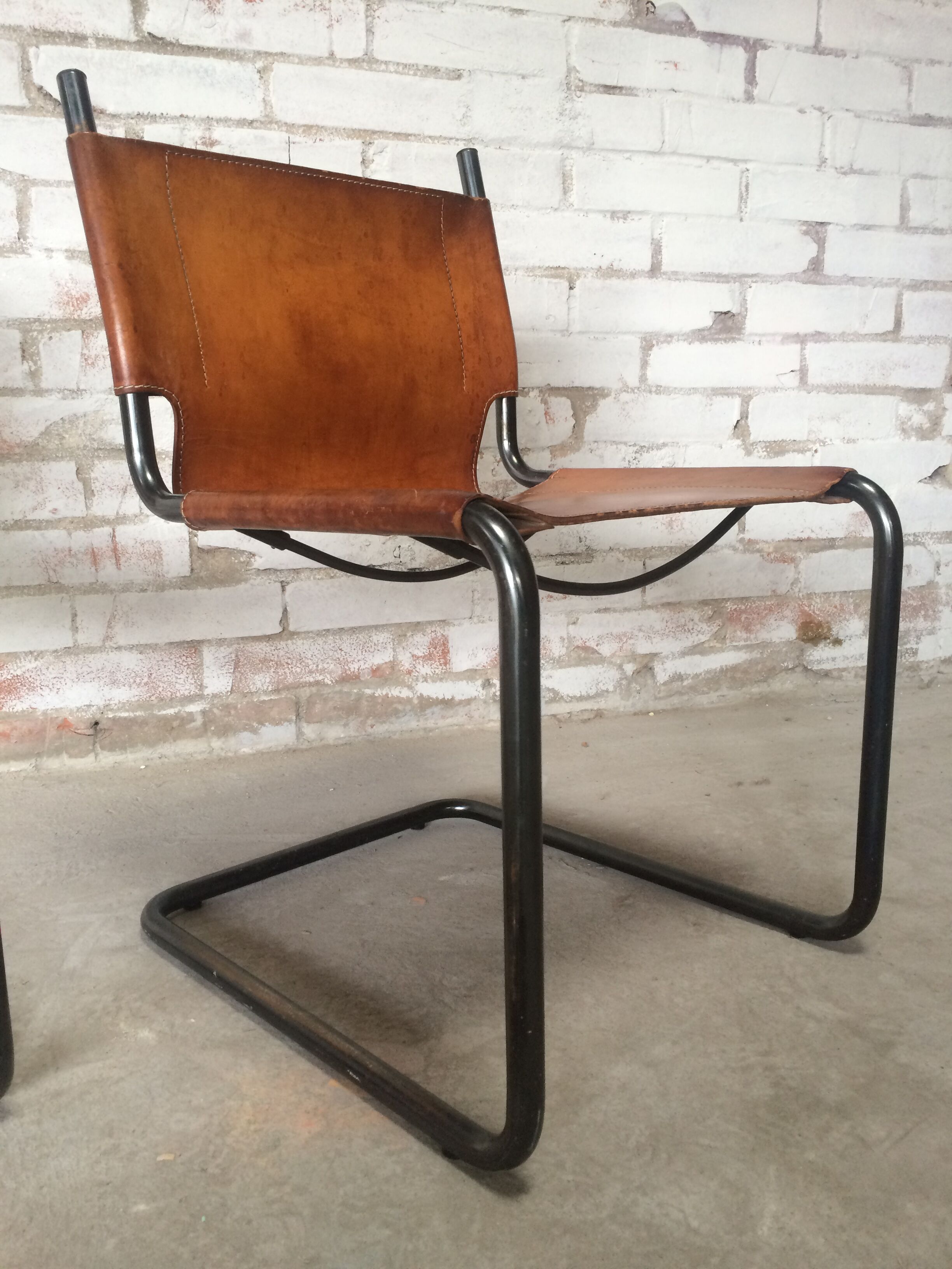 pair of tubular chairs in tawny leather