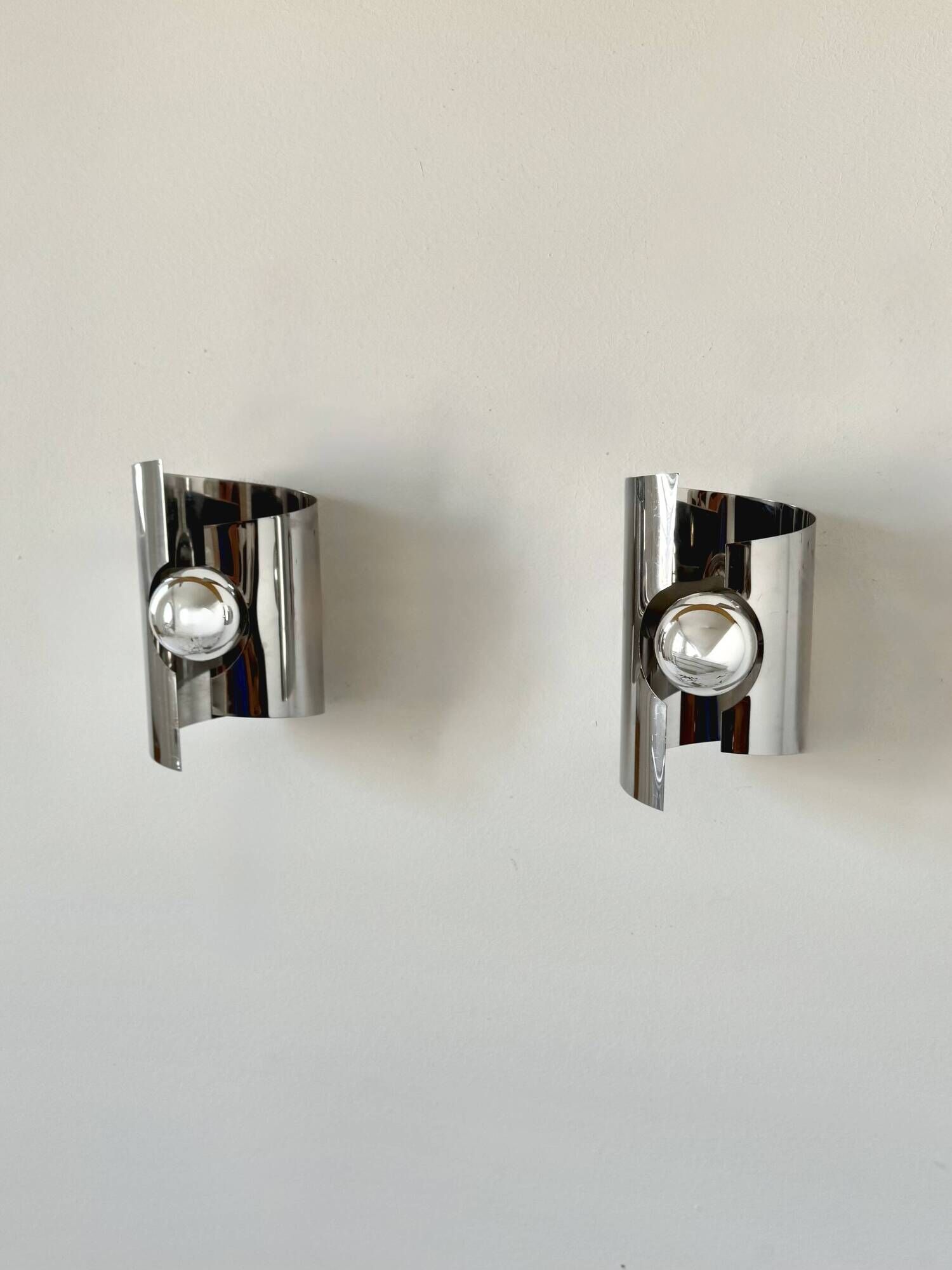Pair of vintage wall lights, curved chrome metal, France, 1970.