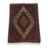 Ancient Persian carpet, wool, red tones, hand-knotted.