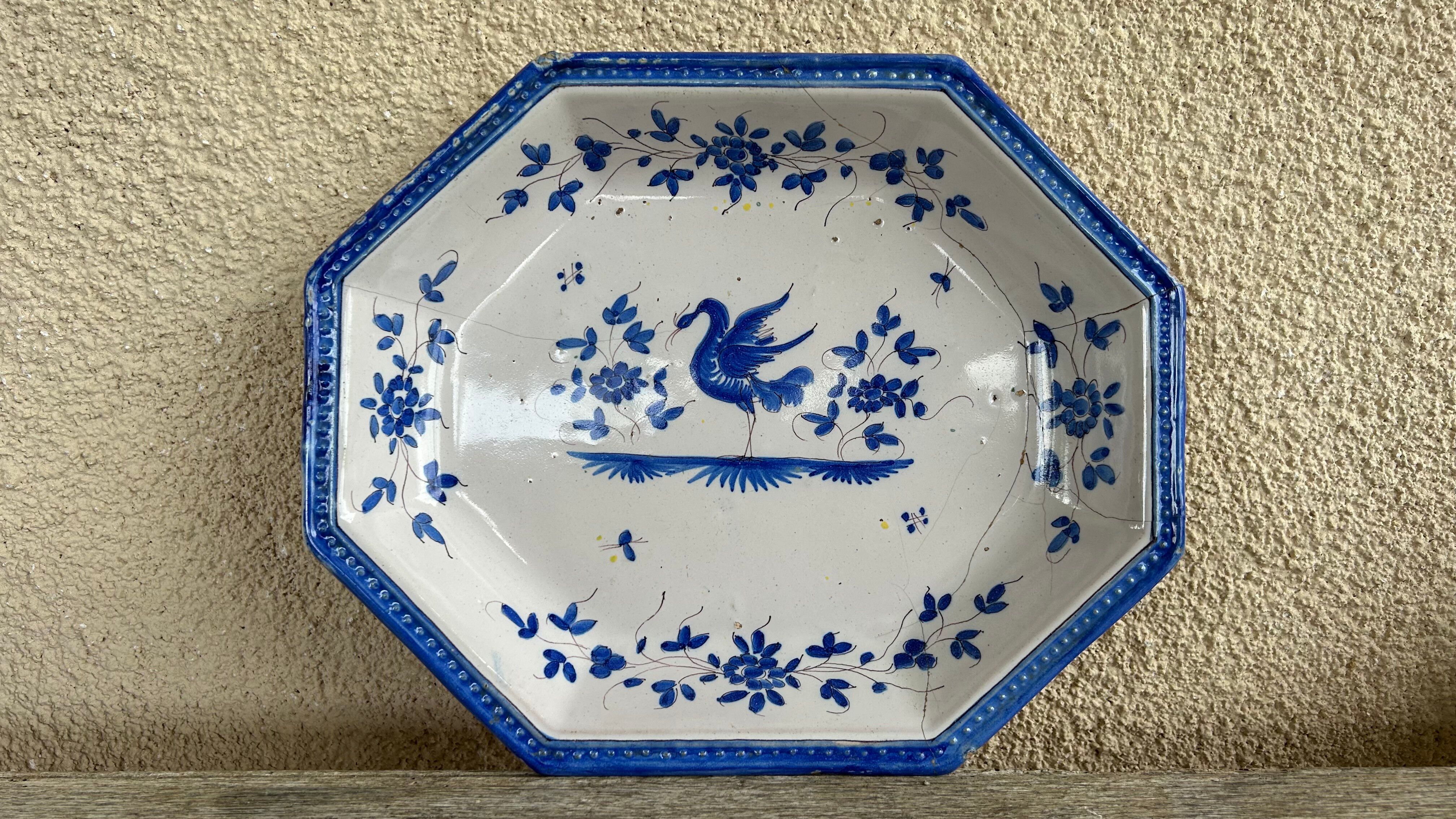 Antique octagonal plate in blue and white pottery with bird decoration.