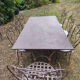 Old wrought iron table and its armchairs and chairs for outdoor use.