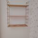 Vintage modular wall shelf in golden steel wire and wood from the 1950s.