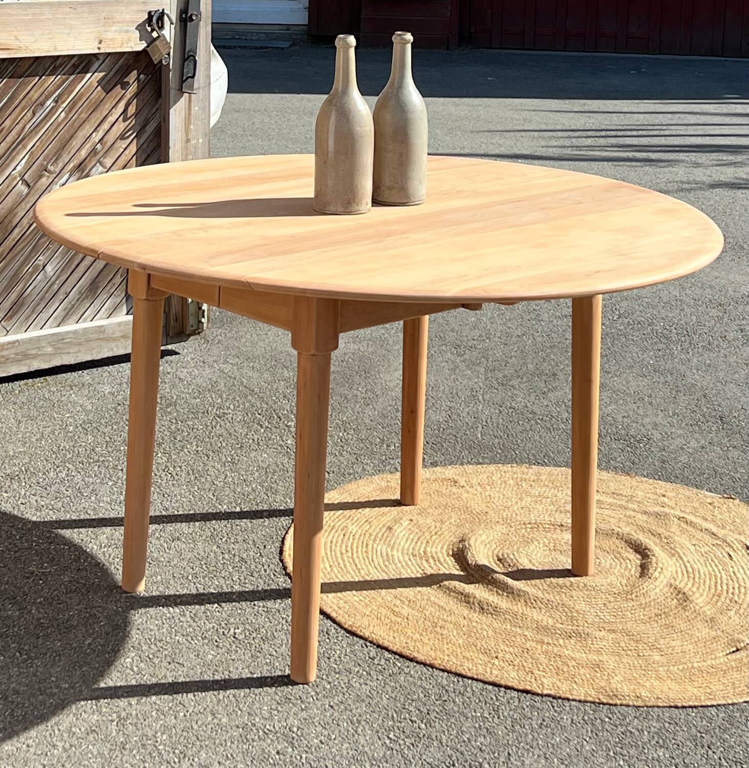 Large round family table with 2 extensions in solid raw wood.