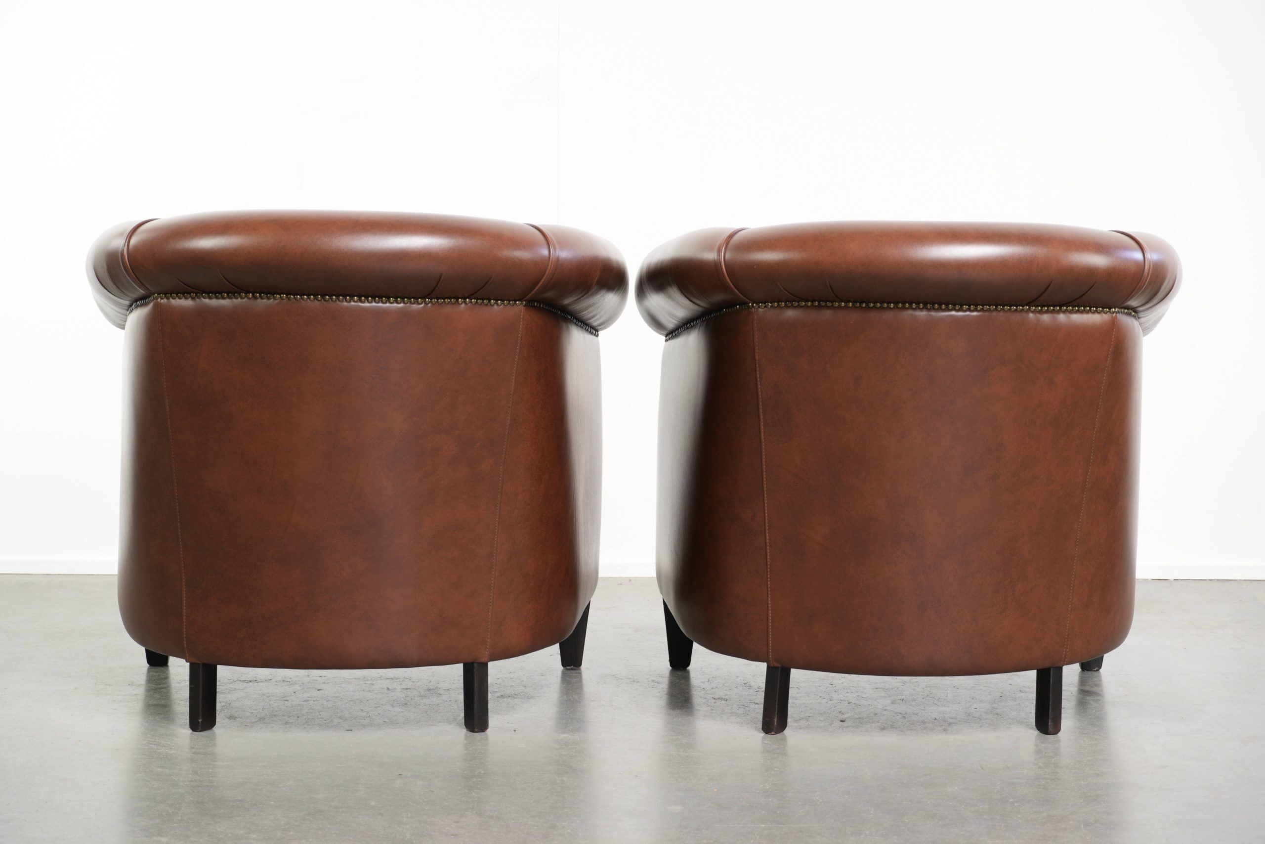 Ensemble de 4 fauteuils club en cuir de vache couleur cognac foncé de style anglais.