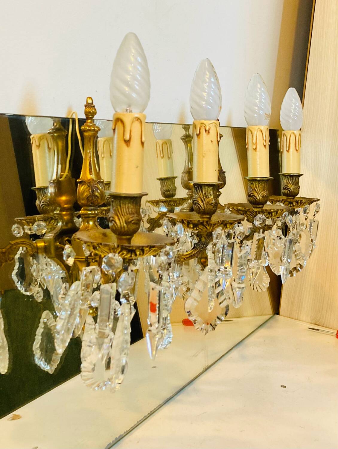 Pair of gilt bronze wall sconces with pendants from the mid-20th century.