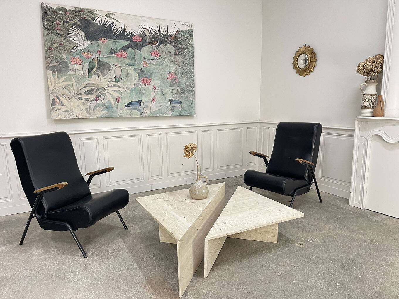 A pair of vintage armchairs in black faux leather.
