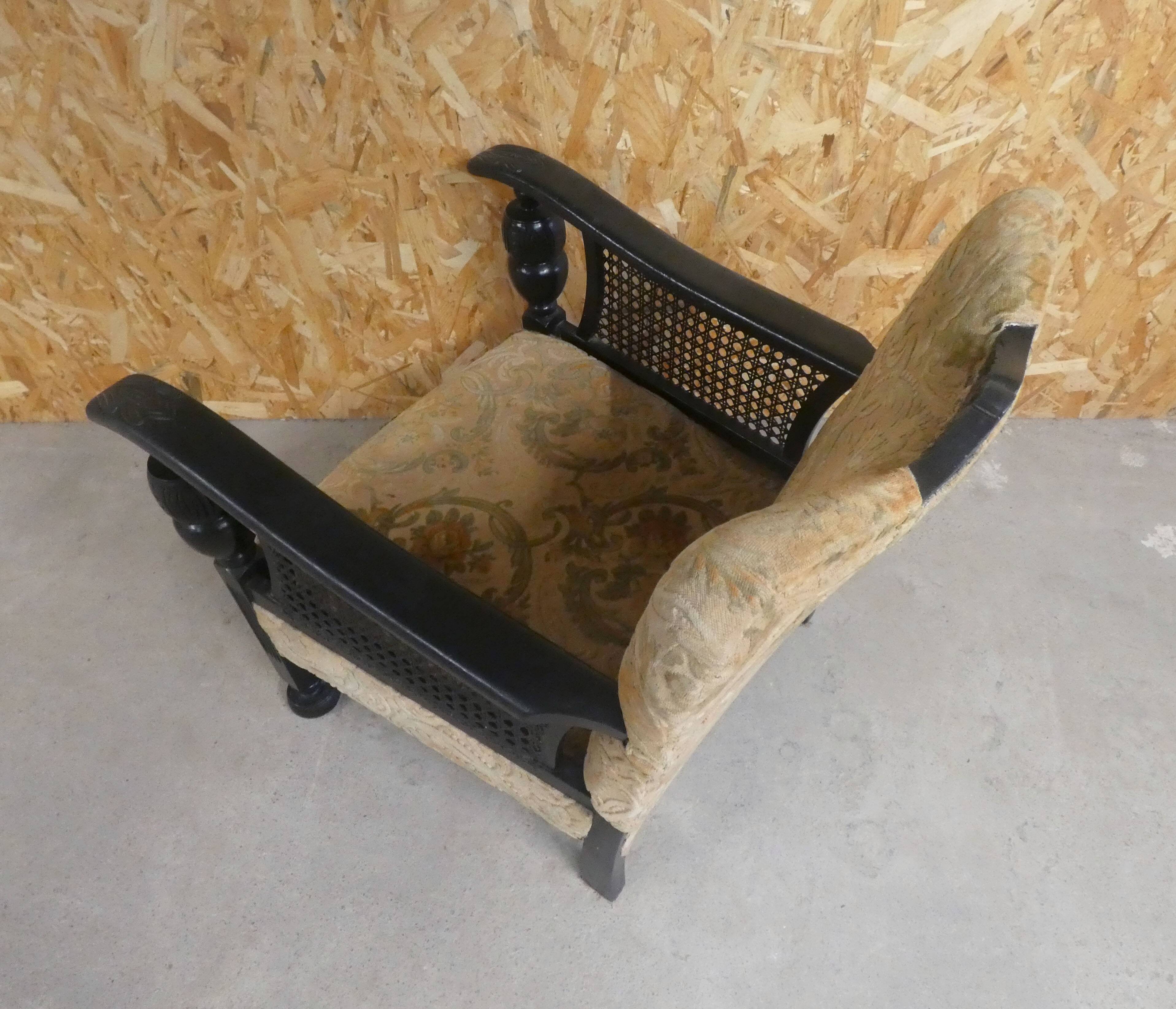 Old armchair upholstered in velvet, carved and caned wood