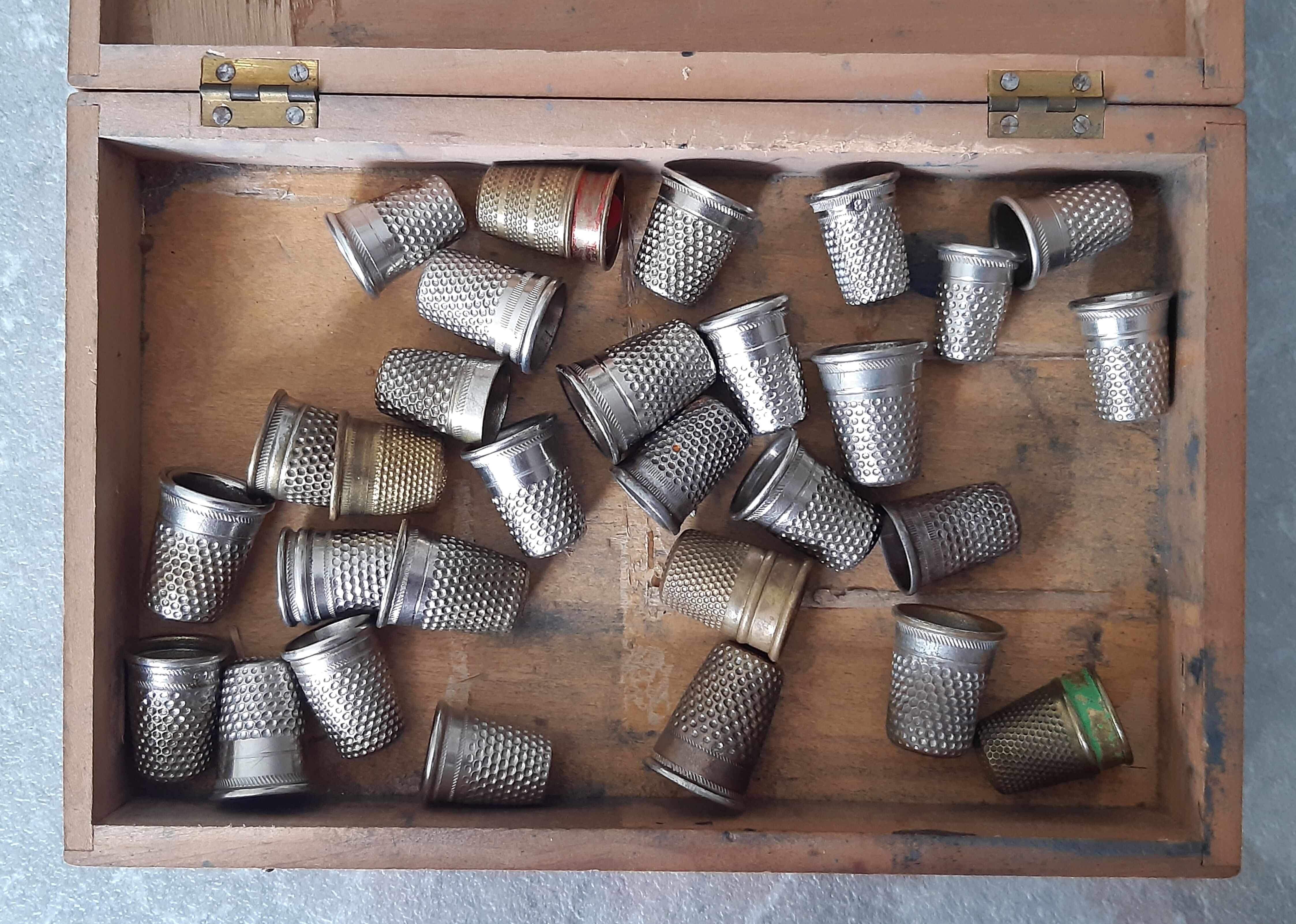 Wooden box containing 30 antique thimbles