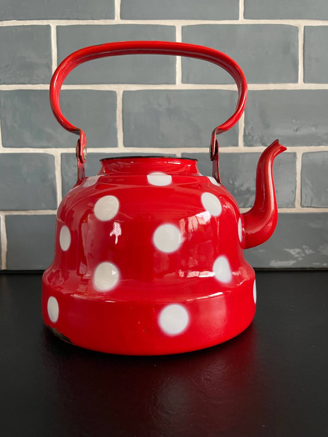 Red enameled sheet metal kettle with white polka dots