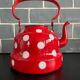 Red enameled sheet metal kettle with white polka dots