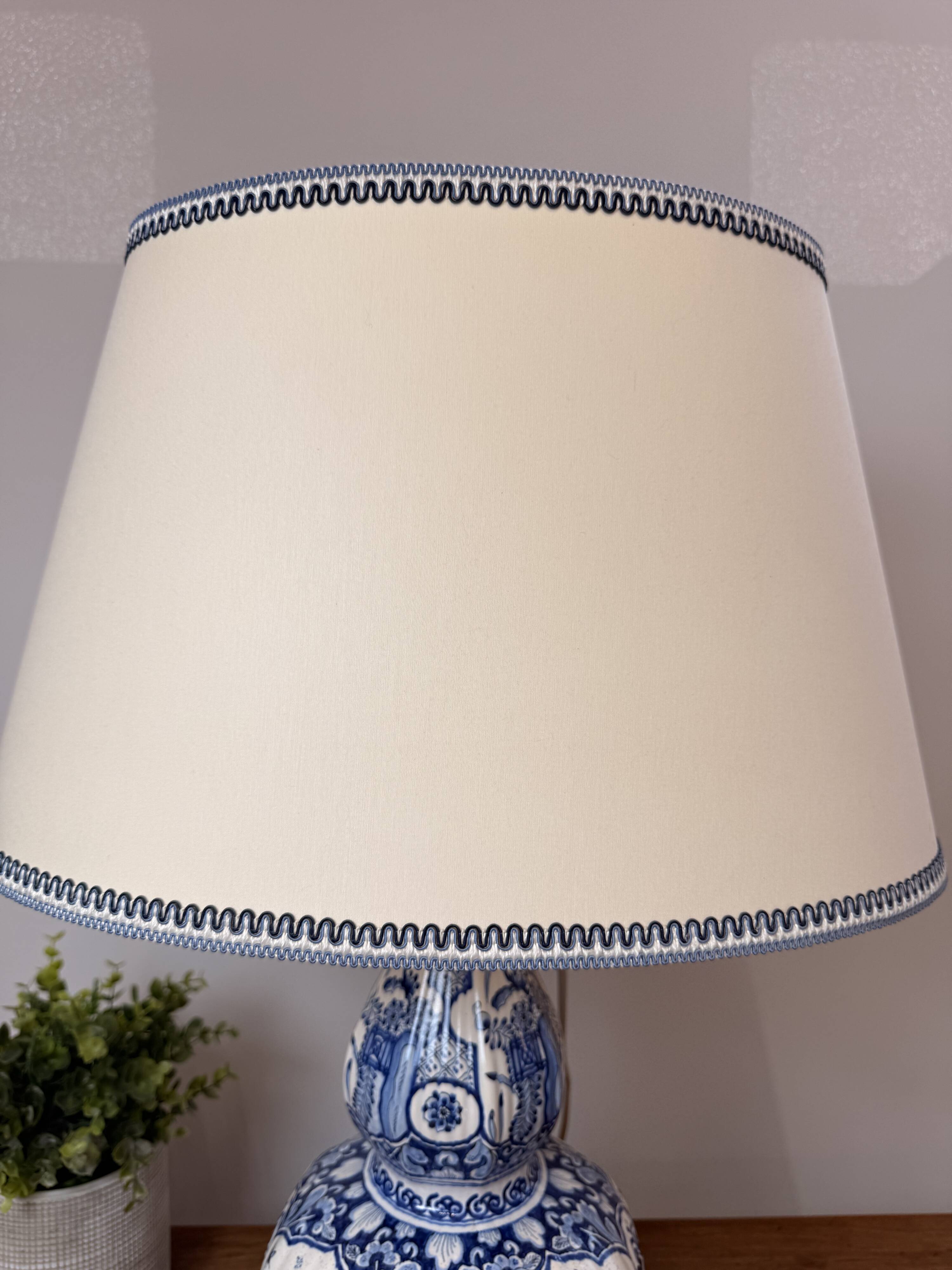Blue and white Delft ceramic table lamp decorated with birds and flowers.