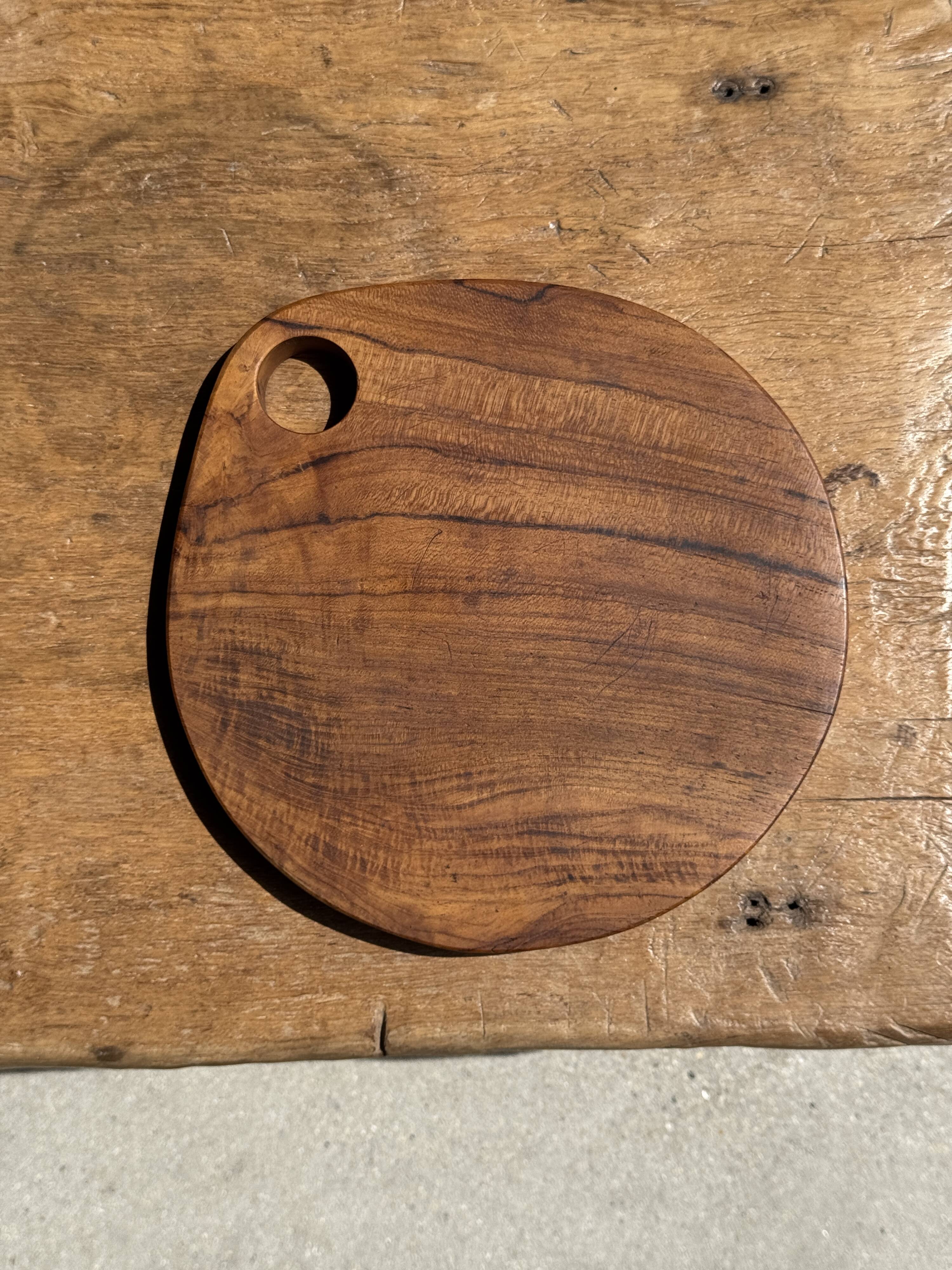 Average circular teak monoxyle chopping board with handle 26 x 18.
