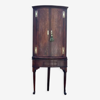 Antique English corner cabinet with a quarter curved front