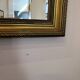 Vintage rectangular wall mirror with a golden wooden frame.