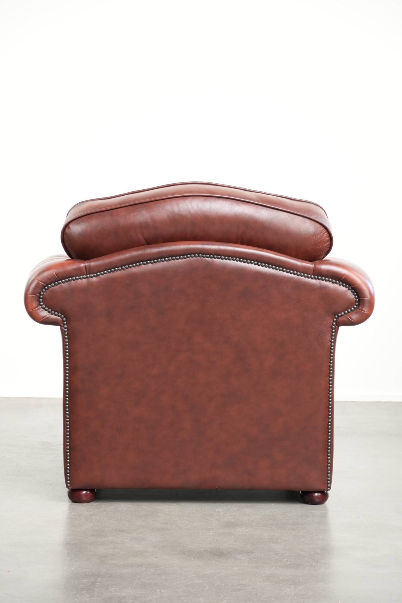 Cowhide chesterfield armchair in a warm brown colour with decorative nails