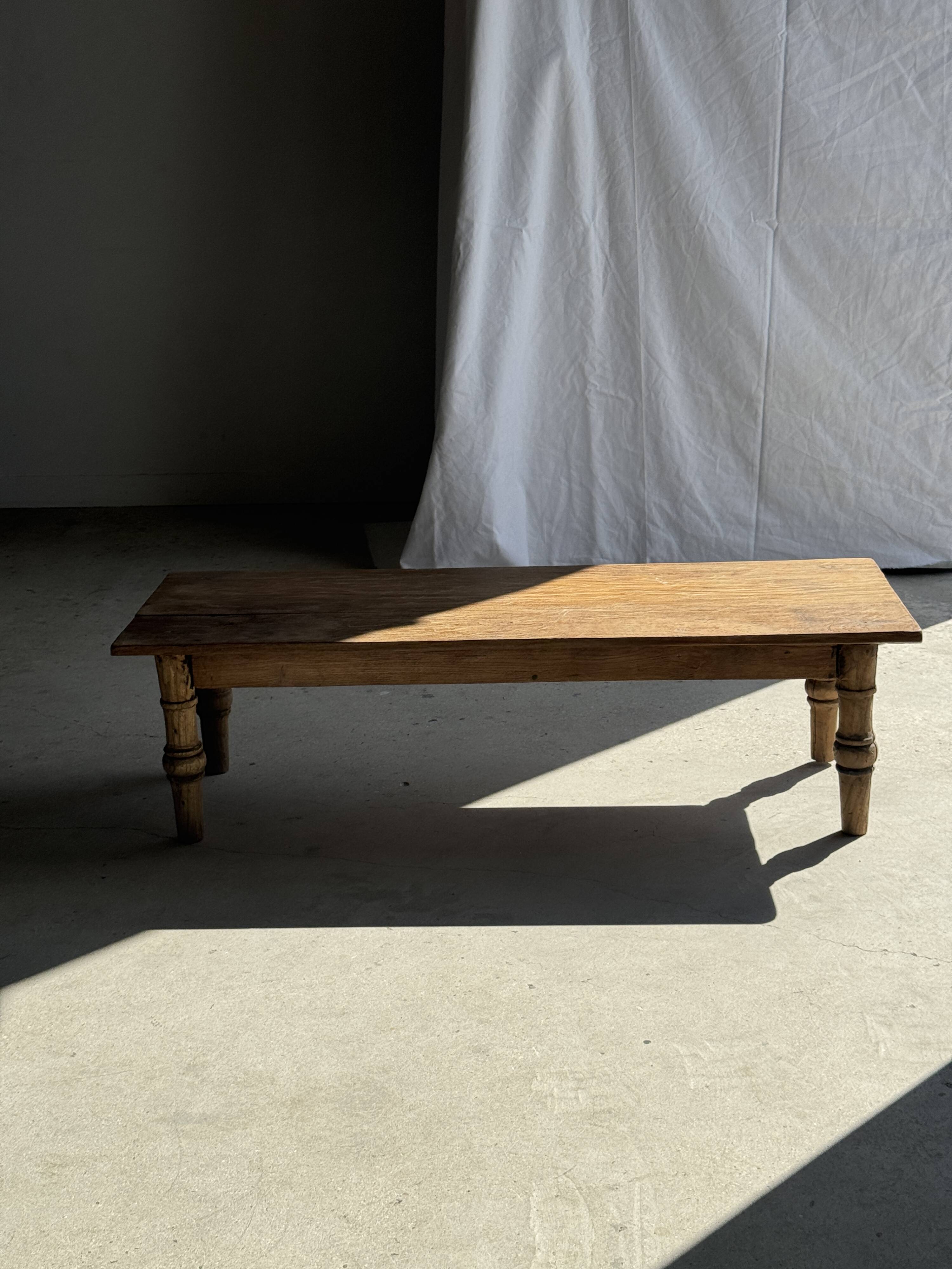 Brown Indonesian teak coffee table, with a border and cylindrical legs H40 L103.