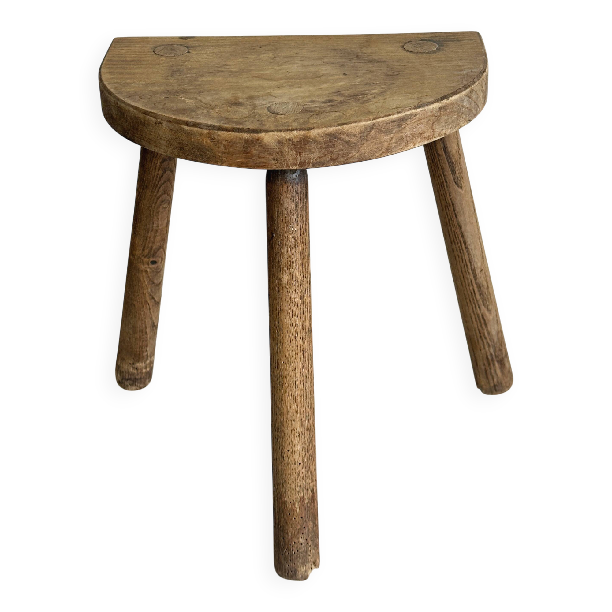 Small antique tripod stool in light wood, half-moon seat.