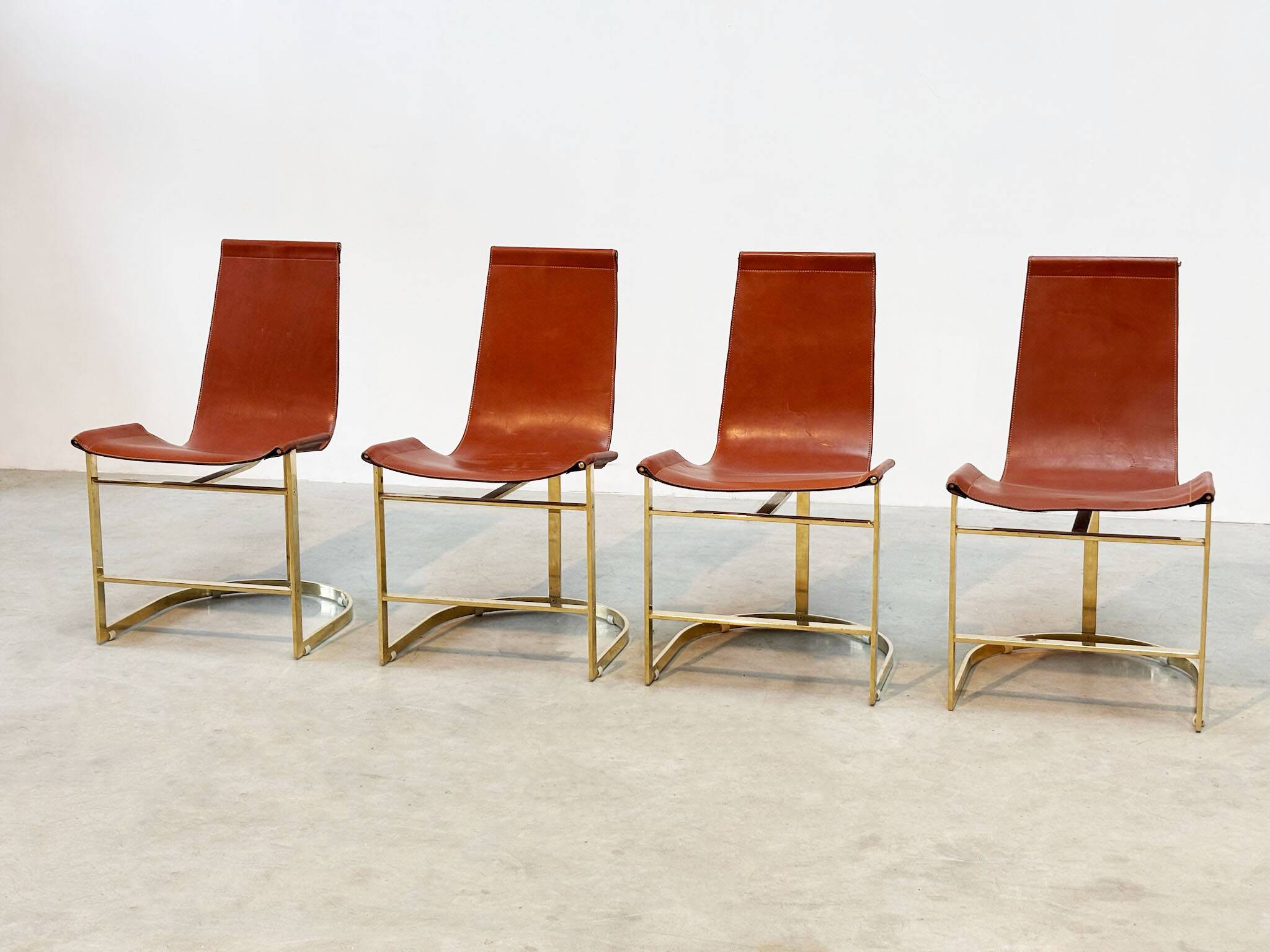 Set of four leather and brass Italian dining chairs
