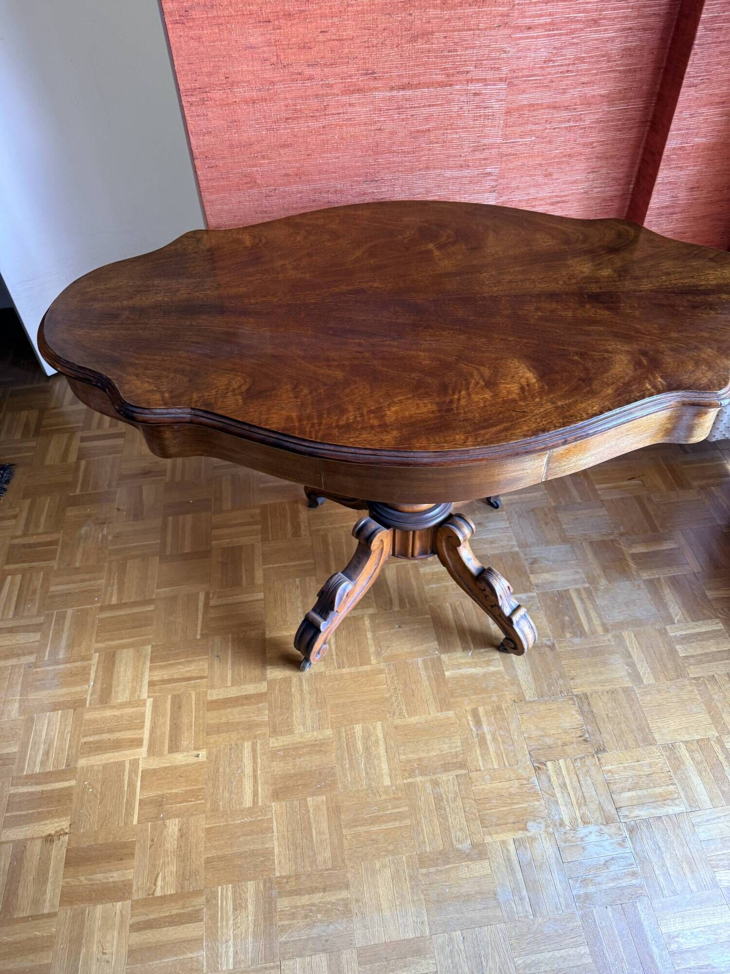 Antique mahogany table with a scalloped top and a sculpted central leg.