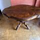 Antique mahogany table with a scalloped top and a sculpted central leg.