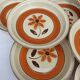 Set 11 plates 1970 Revernay Sarreguemines orange and brown on sandstone background