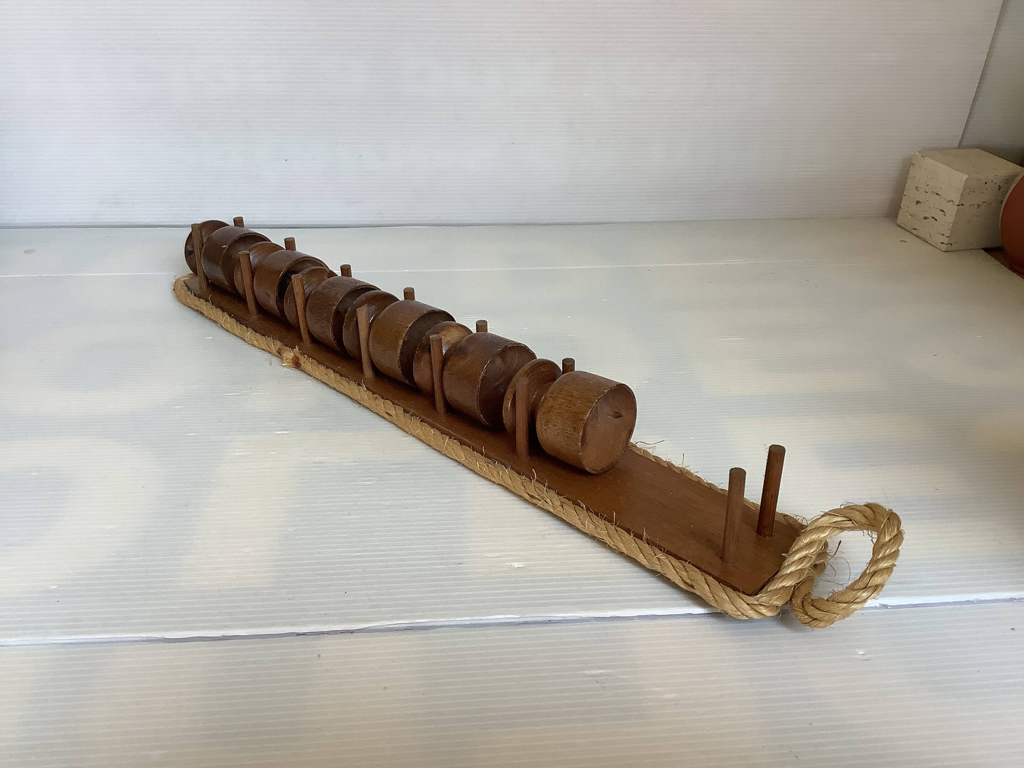 Six wooden egg cups and their rope holder