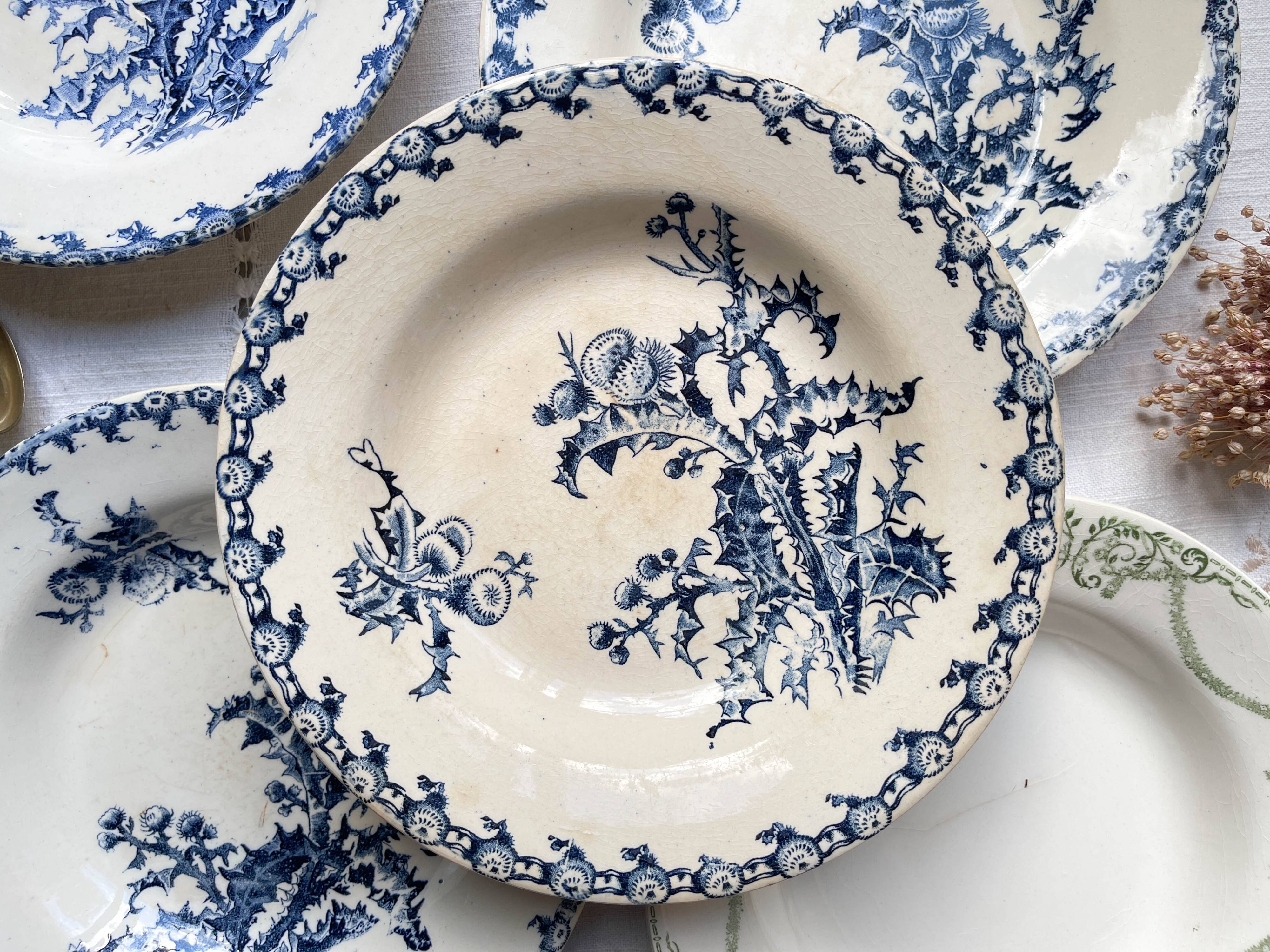 10 mismatched vintage soup plates in blue, green, and red ironstone